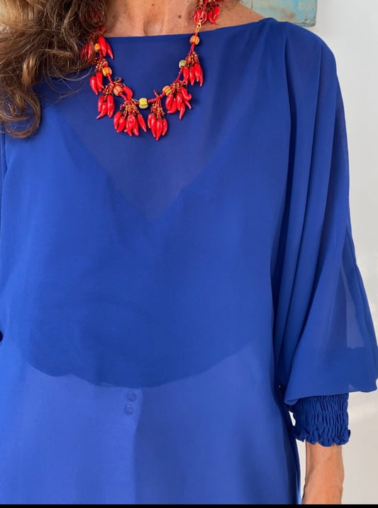 Mujer profesional usando blusón azul rey de corte amplio en oficina