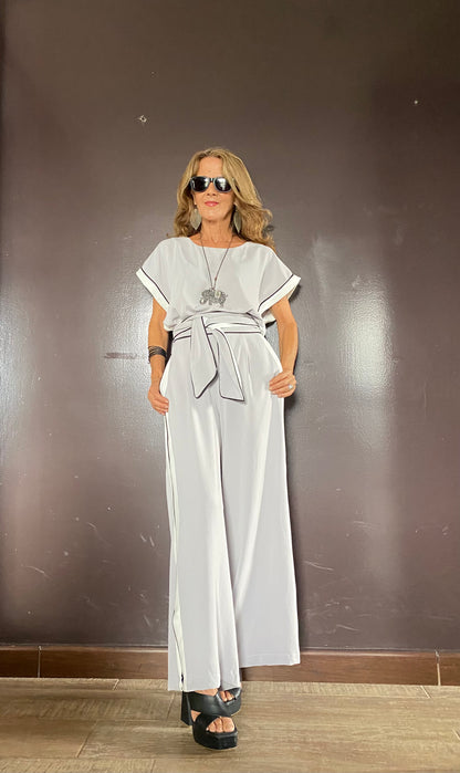 Mujer usando enterizo elegante con cinturón y franjas laterales, ideal para eventos, trabajo o salidas casuales